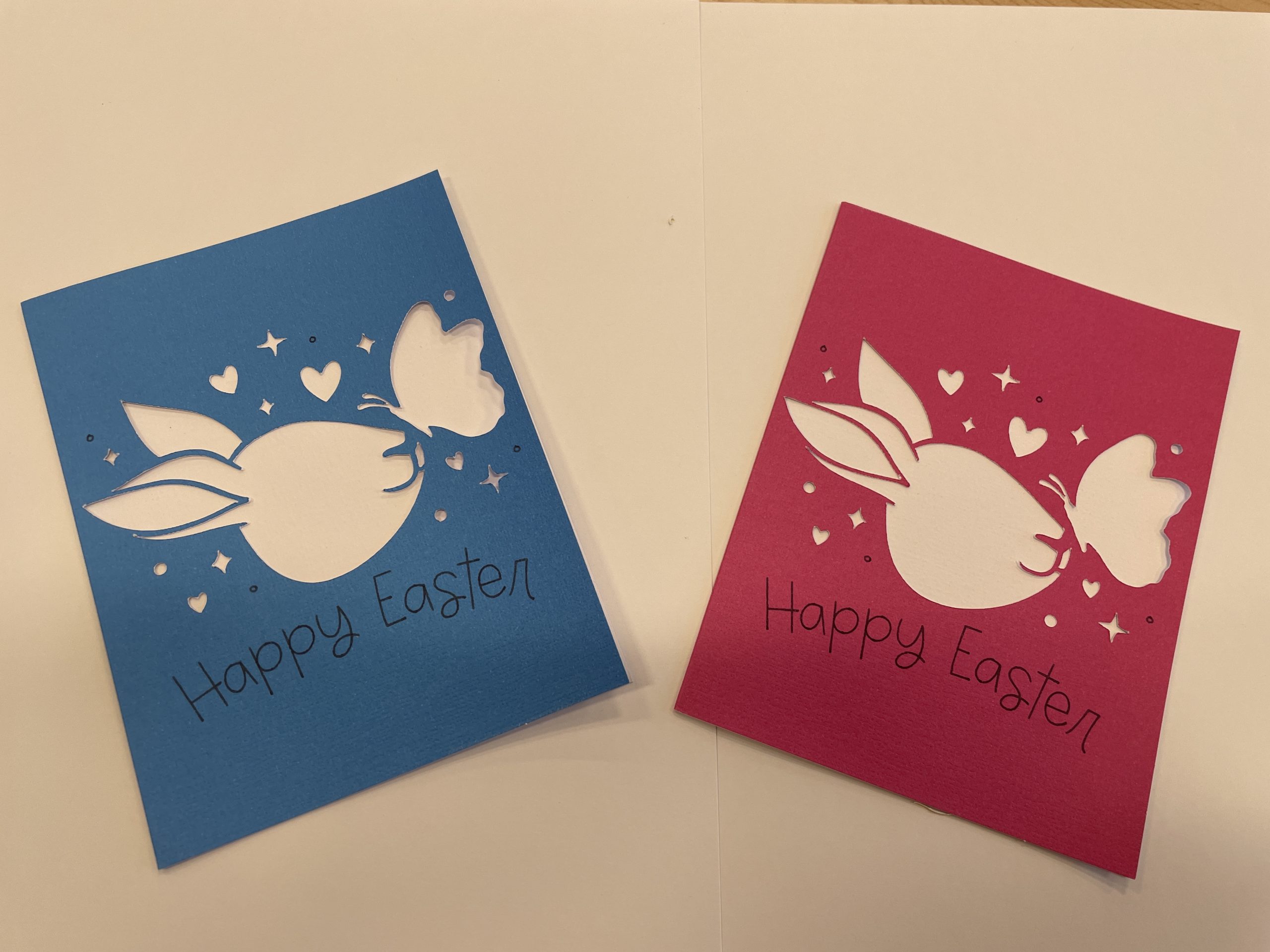 Easter greeting cards with cut-outs of bunnies, hearts, and butterflies. Says "Happy Easter."