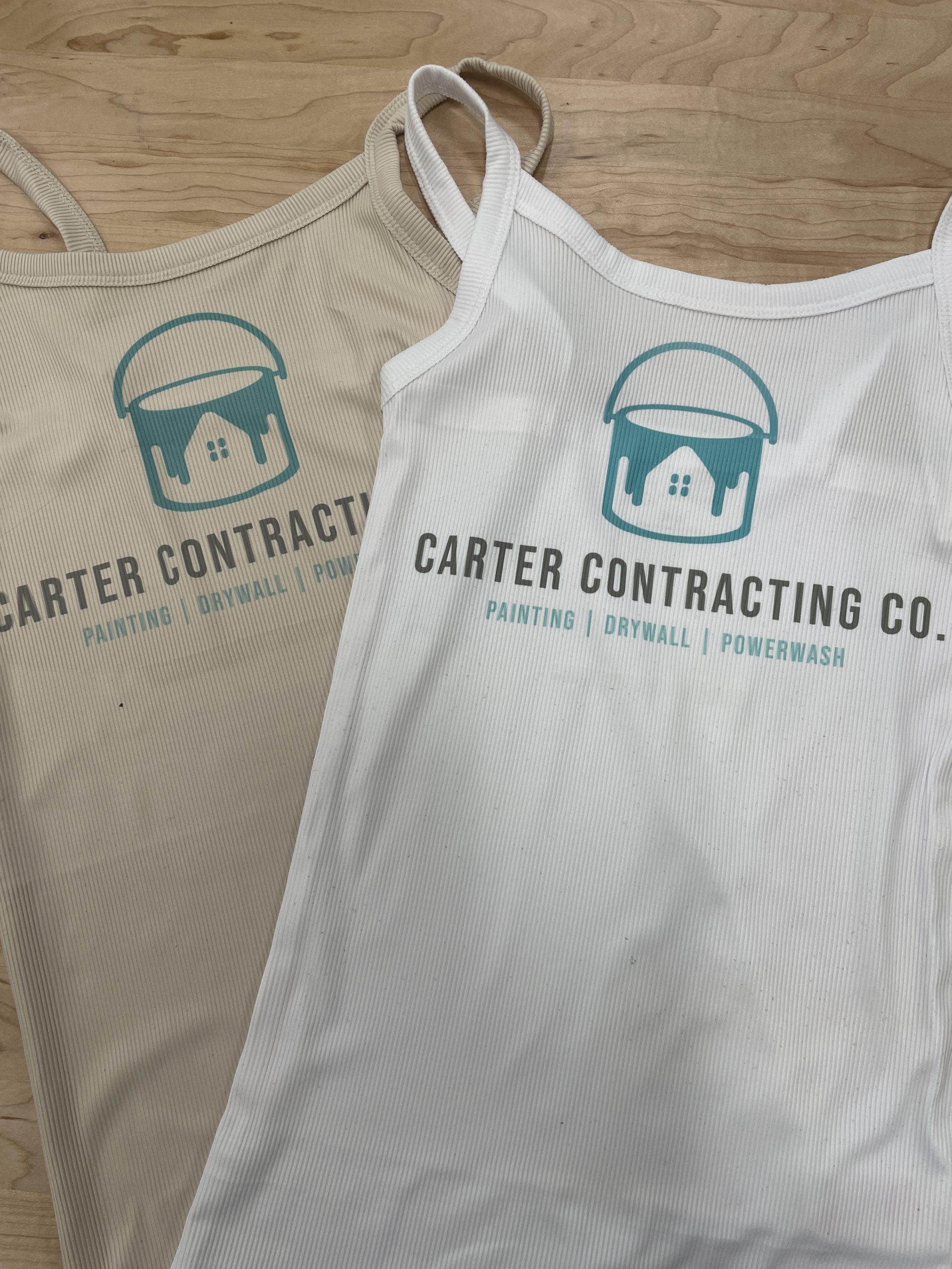 Tan and white women's tank tops with the logo for Carter Contracting Co., painting, drywall, powerwash.