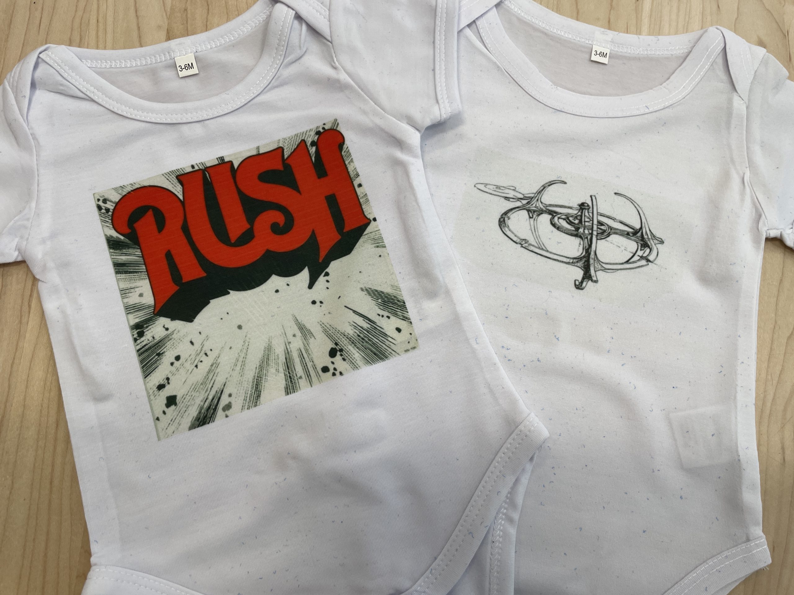 Baby t-shirt onsies with images of rock band album covers.